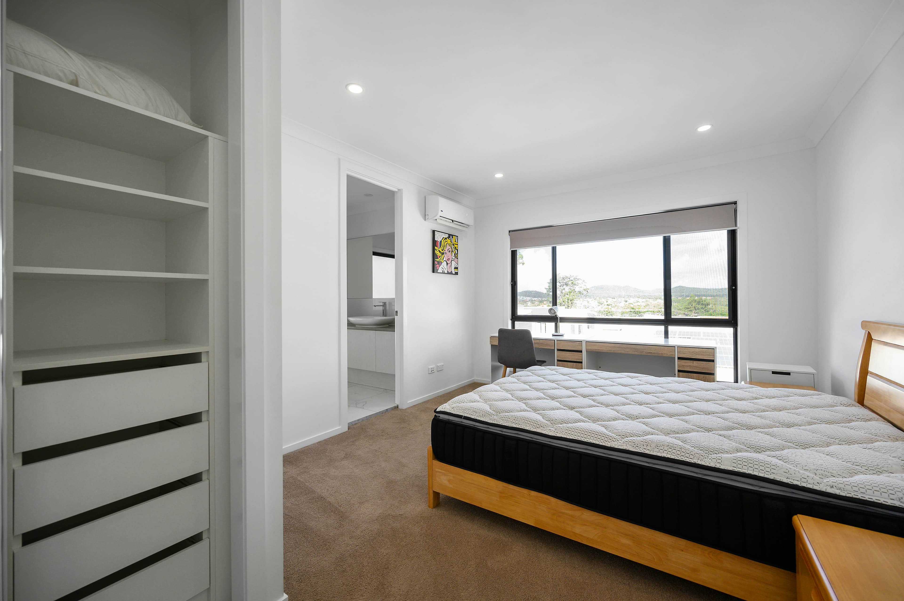 Bedroom with wall-to-wall carpet and bare mattress prepared for professional cleaning